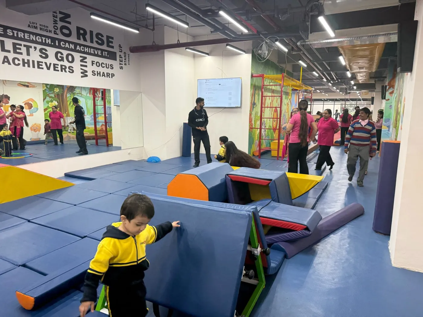 A child climbing over soft-play equipment during a camp session