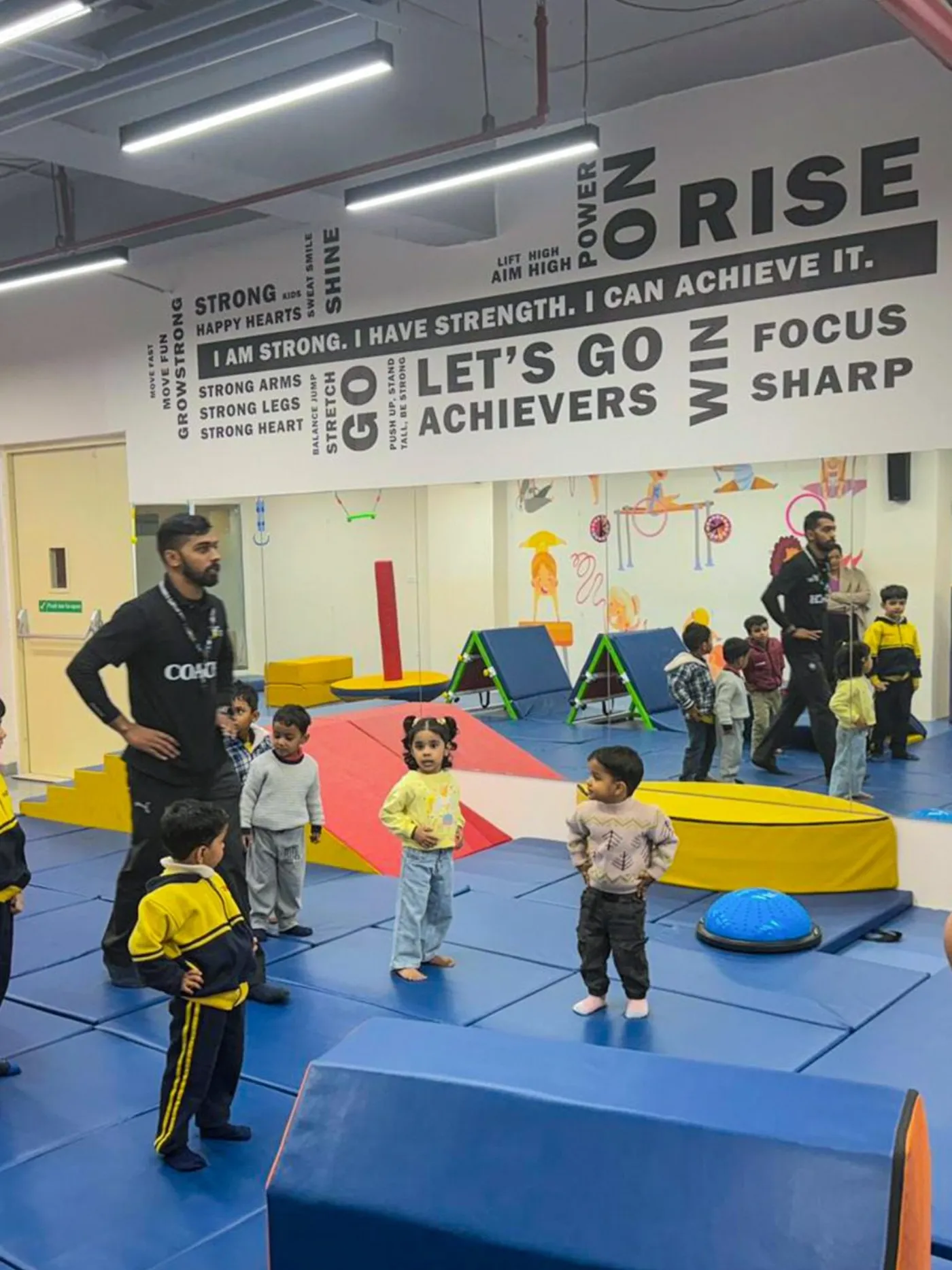 Coach leading a group of young children through a session at the centre