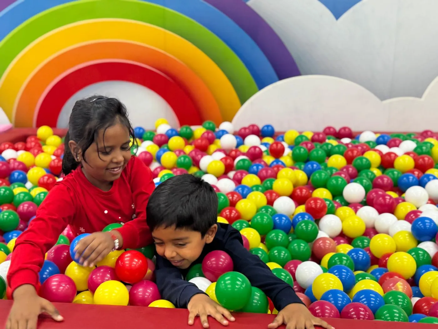Two children playing together in the ball pit at Achievers Care
